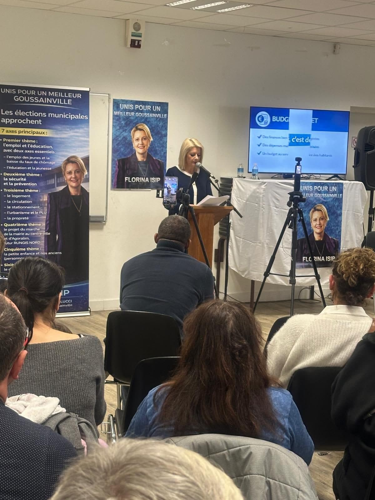 Florina Isip prenant la parole au pupitre lors de la réunion publique de campagne à Goussainville